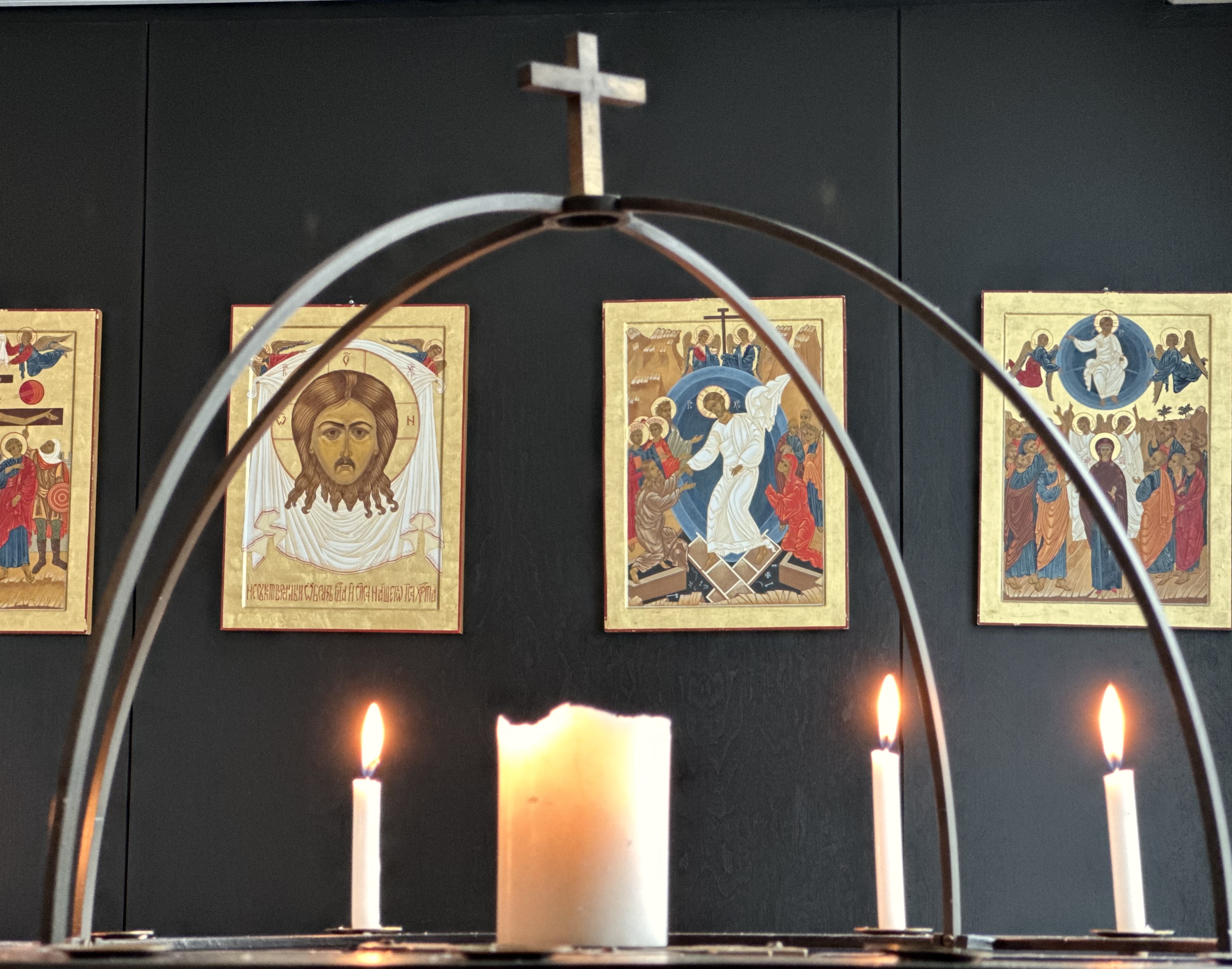 Edessä kynttilöitä sekä risti ja taustalla ikonitauluja.
